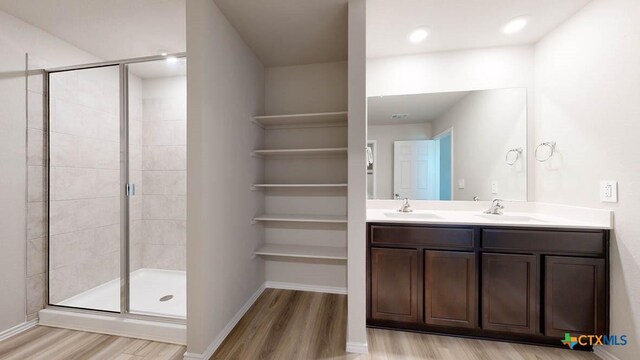 bathroom with vanity, a shower with shower door, and hardwood / wood-style flooring