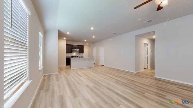 unfurnished living room featuring light hardwood / wood-style flooring and ceiling fan