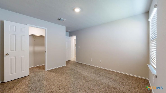 unfurnished bedroom with light colored carpet and a closet