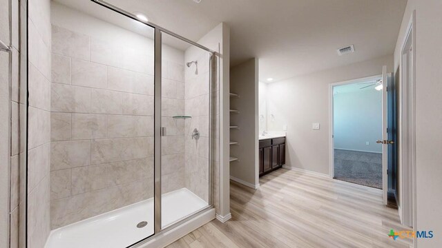 bathroom with ceiling fan, vanity, wood-type flooring, and a shower with shower door