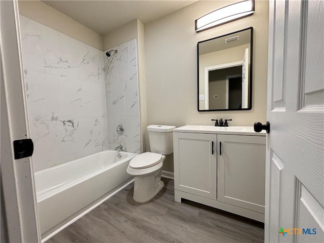 full bathroom featuring vanity, hardwood / wood-style flooring, toilet, and tiled shower / bath