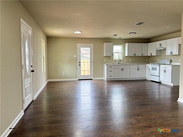 kitchen with white electric range oven, dark hardwood / wood-style flooring, and white cabinetry