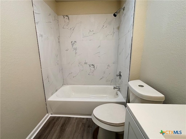 full bathroom featuring hardwood / wood-style flooring, vanity, toilet, and tiled shower / bath combo