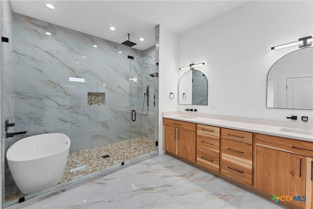 bathroom with vanity and shower with separate bathtub