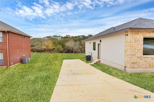 view of yard with central AC unit and a patio area