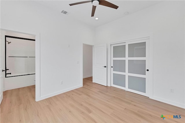 unfurnished bedroom with ceiling fan, a spacious closet, light hardwood / wood-style floors, and a closet