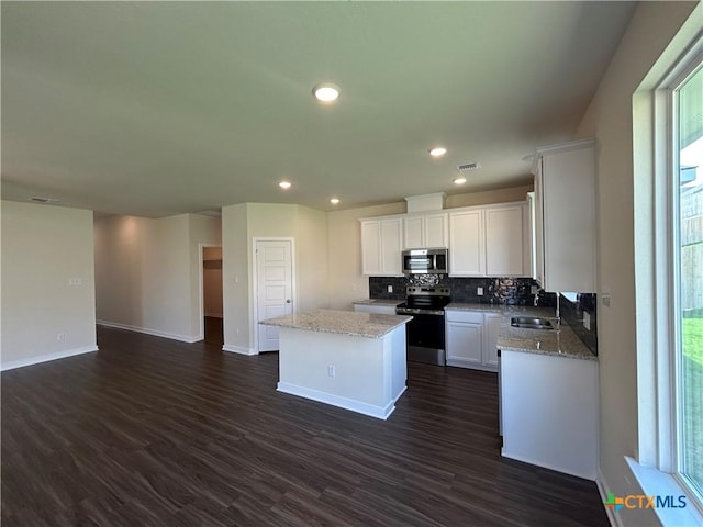 250 Wind Ridge Dr, Copperas Cove, TX 76522 - kitchen featuring a center island, baseboards, a sink, appliances with stainless steel finishes, and decorative backsplash
