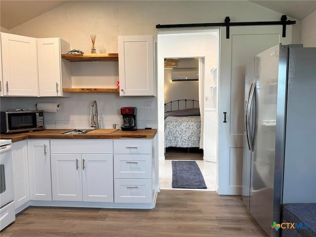 1008 W Dallas Ave, Seadrift, TX 77983 - kitchen with wood finished floors, a sink, wood counters, stainless steel appliances, and lofted ceiling
