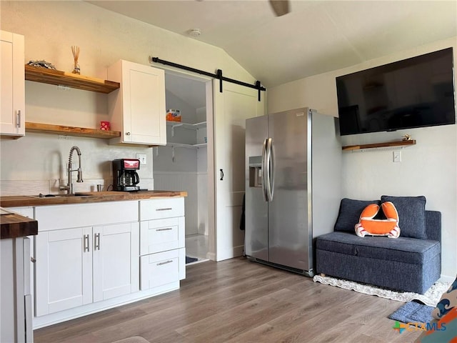 1008 W Dallas Ave, Seadrift, TX 77983 - kitchen with butcher block countertops, white cabinetry, stainless steel fridge with ice dispenser, open shelves, and wood finished floors