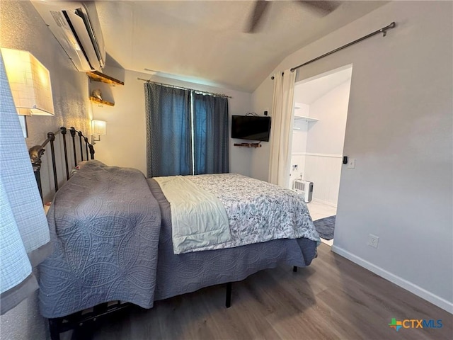 1008 W Dallas Ave, Seadrift, TX 77983 - bedroom with wood finished floors, a wall mounted air conditioner, baseboards, ceiling fan, and vaulted ceiling