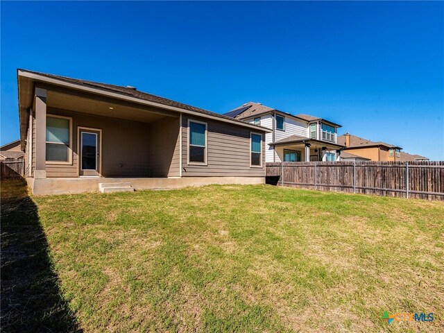 back of property with a lawn and a patio area