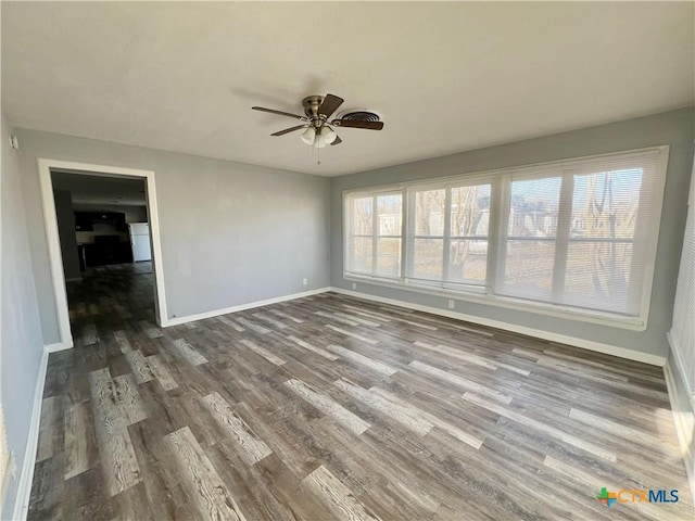 spare room with ceiling fan and dark wood-type flooring