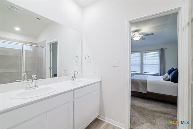 bathroom with a shower with shower door, vanity, ceiling fan, and vaulted ceiling