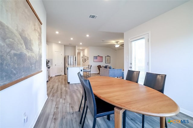 dining area with ceiling fan and light hardwood / wood-style floors