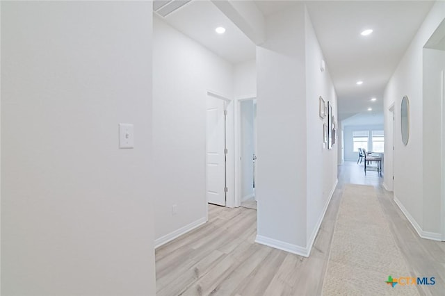 hallway with light hardwood / wood-style floors