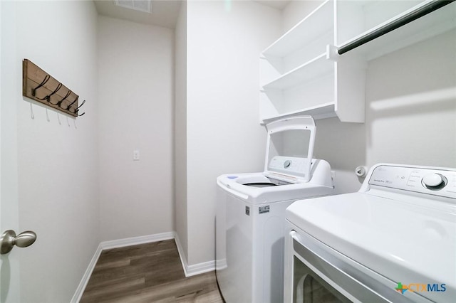 clothes washing area featuring washer and dryer and hardwood / wood-style floors