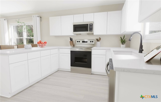 kitchen with white cabinets, appliances with stainless steel finishes, and sink