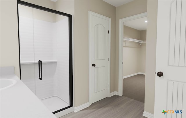 bathroom featuring an enclosed shower and hardwood / wood-style flooring