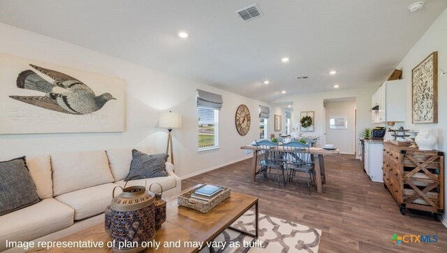 living area featuring visible vents, baseboards, dark wood-style floors, and recessed lighting