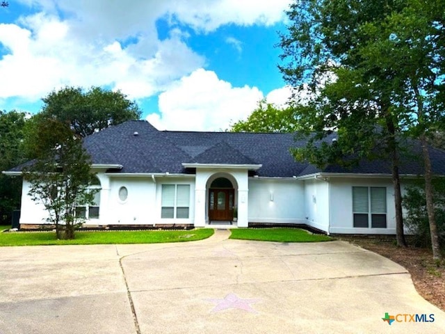 2772 Cloisters Dr, College Station, TX 77845 - view of front of property with roof with shingles, stucco siding, and a front lawn