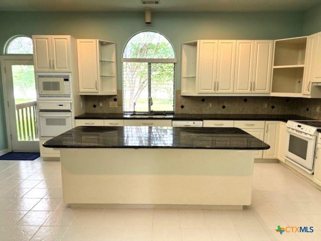 2772 Cloisters Dr, College Station, TX 77845 - kitchen featuring open shelves, white appliances, a kitchen island, and backsplash