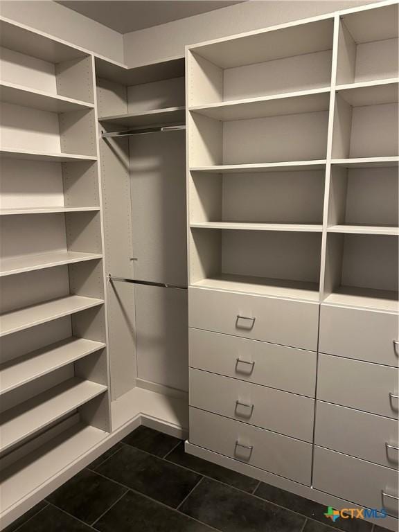 walk in closet featuring dark tile patterned floors