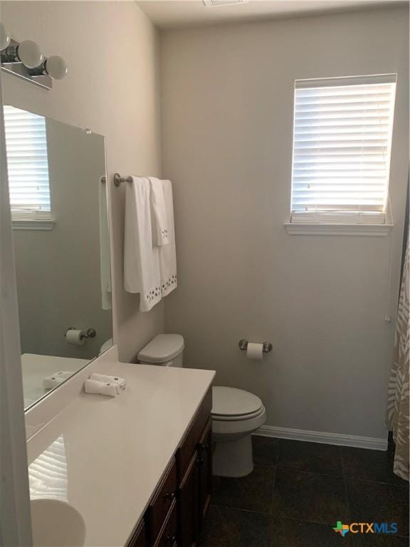 bathroom featuring vanity, tile patterned flooring, and toilet