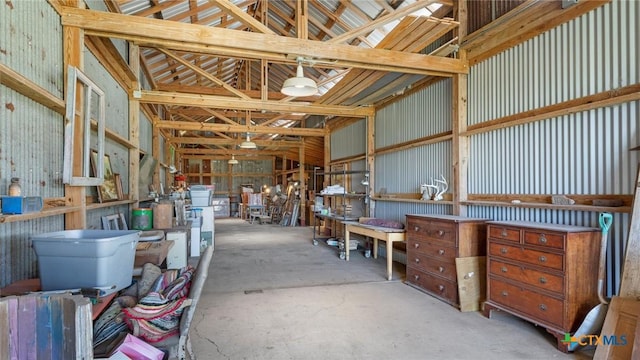 miscellaneous room featuring lofted ceiling, concrete flooring, and metal wall