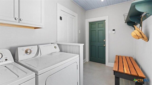 clothes washing area featuring cabinet space and washing machine and clothes dryer