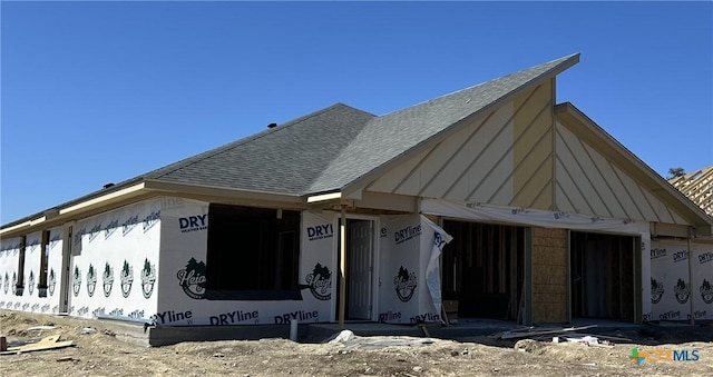 property in mid-construction with an attached garage and roof with shingles