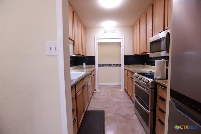 kitchen with decorative backsplash, appliances with stainless steel finishes, light tile patterned floors, and light countertops