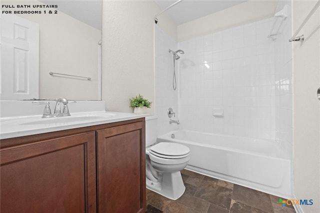 bathroom with vanity, toilet, tub / shower combination, and stone finish flooring