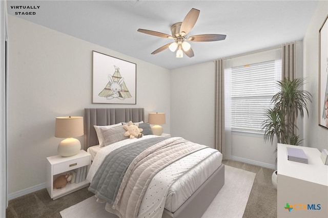 bedroom with multiple windows, a ceiling fan, baseboards, and light carpet