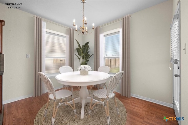 dining room with wood finished floors, baseboards, a chandelier, and a healthy amount of sunlight