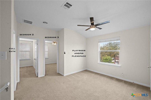 unfurnished bedroom with vaulted ceiling, baseboards, visible vents, and light carpet