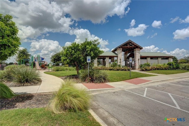 surrounding community featuring a lawn and uncovered parking