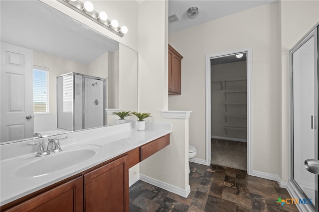 bathroom featuring visible vents, stone finish flooring, a shower stall, baseboards, and vanity