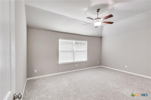 carpeted spare room with baseboards, a ceiling fan, and lofted ceiling
