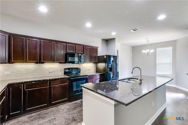 kitchen featuring dark stone counters, visible vents, black appliances, a sink, and decorative backsplash