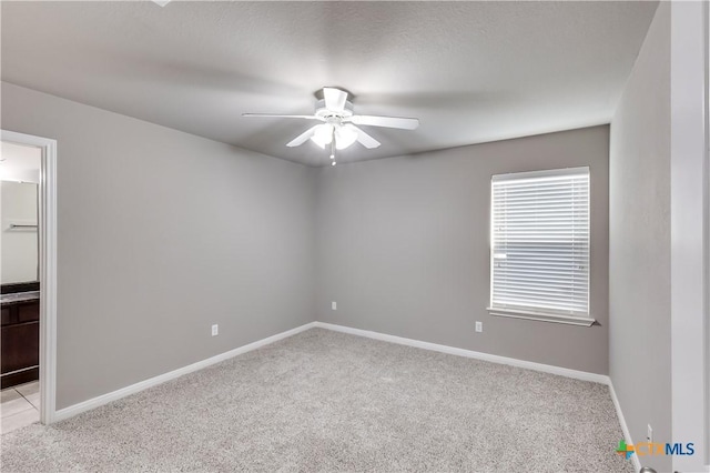 unfurnished room featuring light carpet, ceiling fan, and baseboards