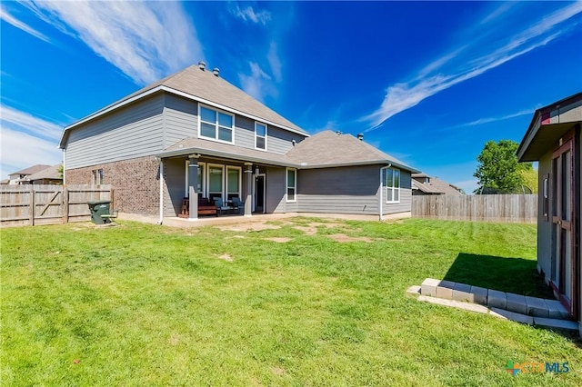 back of house with a patio, a yard, a fenced backyard, and brick siding