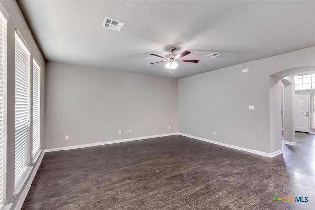 1202 Jester Ct, Copperas Cove, TX 76522 - spare room featuring arched walkways, ceiling fan, and dark wood-style flooring