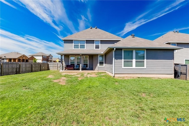 back of property featuring a yard, a fenced backyard, and a patio area