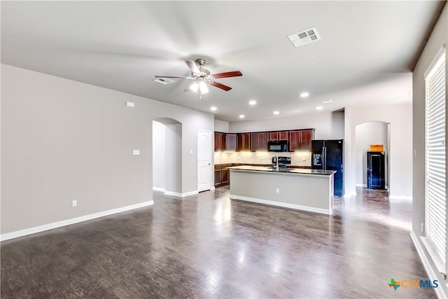 kitchen with open floor plan, arched walkways, visible vents, and black appliances