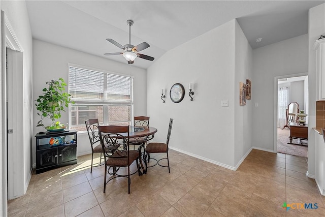 tiled dining area featuring ceiling fan and lofted ceiling