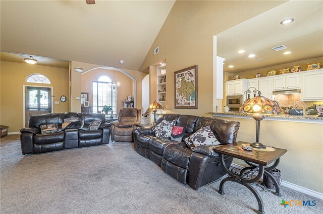 carpeted living room with lofted ceiling and an inviting chandelier