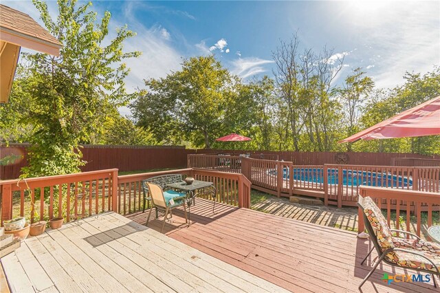 wooden terrace with a fenced in pool