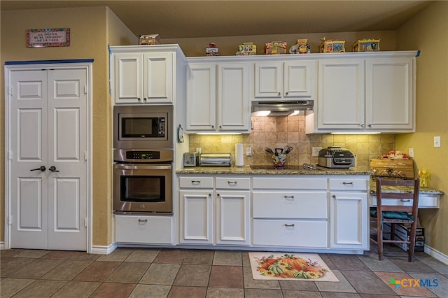 kitchen with backsplash, tile patterned flooring, white cabinetry, and stainless steel appliances