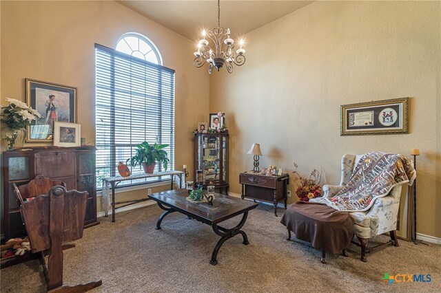 sitting room with carpet floors, a chandelier, and vaulted ceiling