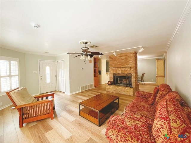3811 River Oaks Cir, Temple, TX 76504 - living room featuring ornamental molding, ceiling fan, light wood-style flooring, a brick fireplace, and baseboards